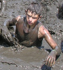boy waist deep in mud